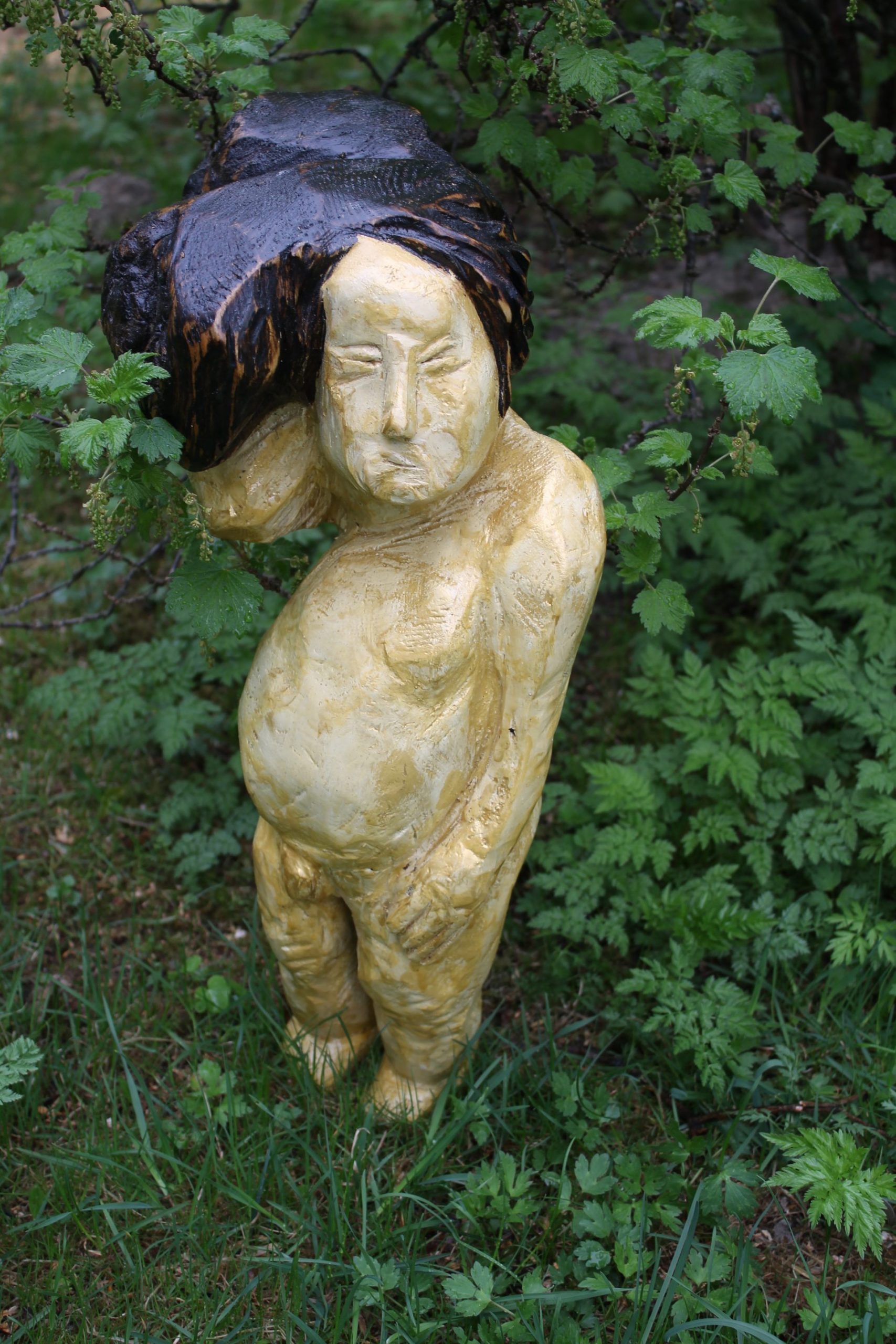 Veistos, joka esittää alastonta poikaa.