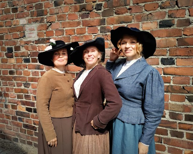 My Fair Ladyn pääroolin Eliza Doolittlen näyttelijät Maria Karhapää, Suvi-Maaria Virta ja Regina Launivuo poseeraavat kuvassa työläisnaisen asussa.